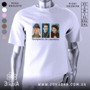 Футболка прекрасні бо українки. Біла футболка з коротким рукавом, зображення трьох персонажів в кольорових костюмах на грудях, текст "Прекрасні, бо українки!" під ними, фон нейтральний, без зайвих деталей.