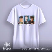 Футболка прекрасні бо українки. Біла футболка з коротким рукавом, зображення трьох персонажів в кольорових костюмах на грудях, текст "Прекрасні, бо українки!" під ними, фон однорідний, без зайвих деталей.