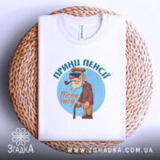 Футболка принц пенсії, білого кольору, складена на плетеній основі, фон світло-сірий, принт з мультяшним персонажем у капелюсі та окулярах, тримає тростину, текст 'Пісні часу' під персонажем.