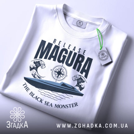 Футболка Release Magura білого кольору, зображена зверху, на ній прикріплена етикетка зеленого кольору, фон світлий, принт з човном та хвилями, текст 'THE BLACK SEA MONSTER'.