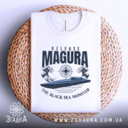 Футболка Release Magura білого кольору, зображена зверху на плетеній основі, фон нейтральний, принт з човном та хвилями, текст 'THE BLACK SEA MONSTER' під ним.