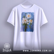 Футболка ромашки, білого кольору, підвішена на вішалці, фон світло-сірий, принт з трьох ромашок на блакитному фоні, з зеленим листям.