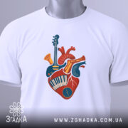 Футболка серце музиканта, біла, зображена зверху, на фоні світло-сірого кольору, принт з серцем, що містить музичні інструменти, прикрашений етикеткою з логотипом бренду.