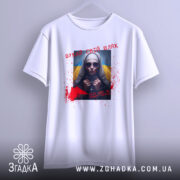 Футболка шукай свій шлях. Біла футболка, що висить на вішалці, з принтом на грудях, зображаючи жінку в темних окулярах. Фон світло-сірий, принт доповнений червоними плямами та написом українською мовою.