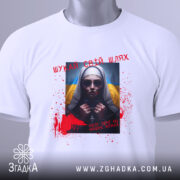 Футболка шукай свій шлях. Біла футболка, зображена зверху, з принтом на грудях, що показує жінку в темних окулярах. На фоні видно жовто-блакитний прапор, а також червоні плями, що нагадують кров, та напис українською мовою. На комірці видно етикетку.