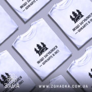 Футболка шукайте в лісі, біла, зображена на манекені, фон світло-сірий, принт чорний з ведмедем та деревами, текст українською мовою.