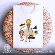 Футболка сюрреал арт скелет, біла, складена на круглому кошику, фон світло-сірий, принт з жовтим сонцем, скелетом, повітряною кулею, короною та геометричними фігурами.