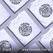 Футболка Слава Україні, білого кольору, зображена на манекені з правого боку, фон світло-сірий, принт чорного кольору з тризубом та написом 'Слава Україні! Героям Слава!' у декоративному обрамленні.