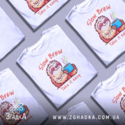 Футболка Slow Brew релакс білого кольору, зображена з фронтального ракурсу на манекені, фон нейтральний, принт з ведмедем-лінивцем, який тримає чашку з парою, текст 'Slow Brew' і 'Take it easy' виконаний у яскравих кольорах.
