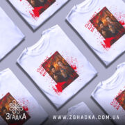 Футболка сьогодні хороший день. Біла футболка з коротким рукавом, зображена з фронтального ракурсу на манекені. На футболці яскравий принт з двома персонажами, які показують жест, що символізує протест, на фоні червоних плям, що нагадують кров. Текст на футболці виконаний червоним кольором.