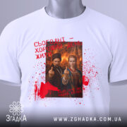 Футболка сьогодні хороший день. Біла футболка, розкладена на поверхні, з видимим етикеткою. Принт на футболці той же, що й на попередній, з червоними плямами та текстом. Фон нейтральний, що підкреслює дизайн футболки.