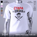Футболка стара школа, біла, зображена з фронтального ракурсу, фон нейтральний, принт містить червоний напис 'СТАРА' та чорний 'ШКОЛА', зображення черепа з капелюхом та двома ножами, деталі принта чіткі.