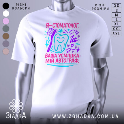 Футболка стоматолог білого кольору, зображена на манекені, фон світло-сірий, принт містить текст "Я - стоматолог. Ваша усмішка - мій автограф" у яскравих кольорах: рожевому, блакитному та фіолетовому, з малюнком зуба та зубної щітки.