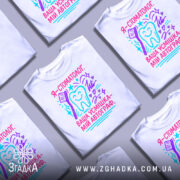 Футболка стоматолог білого кольору, зображена на манекені, фон світло-сірий, принт містить текст "Я - стоматолог. Ваша усмішка - мій автограф" у яскравих кольорах: рожевому, блакитному та фіолетовому, з малюнком зуба та зубної щітки.