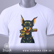 Футболка стоп війна, біла, зображена зверху, фон світлий, принт з доберманом, що тримає табличку 'STOP WAR', на футболці є етикетка з зеленим шнурком.