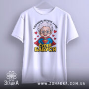 Футболка супер бабуся, біла, зображена на манекені, фон світло-сірий, принт з бабусею в червоному плащі, з написом 'СУПЕР БАБУСЯ'.