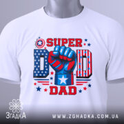 Футболка супер тато, біла, зображена зверху, складена на поверхні, фон світлий, принт яскравий з червоним, синім та білим кольорами, кулак з написом 'SUPER DAD' та елементами зірок.