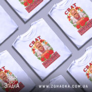 Футболка сват білого кольору, зображена на манекені з правого боку, фон світло-сірий, принт з чоловіком у вишиванці, оточеним червоними трояндами та кольоровими квітами, напис 'СВАТ' зверху.