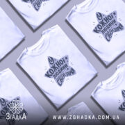 Футболка свої зірки. Біла футболка з коротким рукавом, зображена з правого ракурсу на манекені. Фон світло-сірий, принт у формі зірки з текстом "У кожної людини свої зірки" у темно-сірому кольорі.