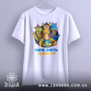 Футболка сила злість характер. Біла футболка, підвішена на вішалці, з принтом дракона з трьома головами. Фон світло-сірий, принт яскравий, акцент на емоційному виразі дракона.