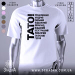 Футболка тато білого кольору, зображена на манекені з правого боку, фон світло-сірий, принт чорного кольору з написом 'TATO!' та переліком позитивних якостей тата.