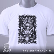 Футболка темний демон, біла, зображена на столі, ракурс зверху, фон світло-сірий, принт з чорними деталями, на якому зображений демон, ведмедик і черепи, з етикеткою зеленого кольору.