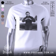 Футболка темний романтик, біла, зображена на манекені, з принтом чорного персонажа, що робить жест серця, на фоні автомобіля.