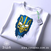 Футболка тризуб білого кольору, зображена в горизонтальному положенні на білому фоні, принт тризуба жовтого кольору на синьому фоні, з етикеткою на зеленому шнурку.