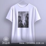 Футболка Ukraine білого кольору, підвішена на вішалці, фон світло-сірий, принт з чорнобілими зображеннями дерев та написом 'UKRAINE' по центру.