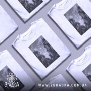 Футболка Ukraine білого кольору, зображена з фронтального ракурсу на манекені, фон світло-сірий, принт з чорнобілими зображеннями дерев з написом 'UKRAINE' по центру.