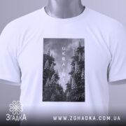 Футболка Ukraine білого кольору, складена на поверхні, з видимим етикеткою, фон світло-сірий, принт з чорнобілими зображеннями дерев та написом 'UKRAINE' по центру.