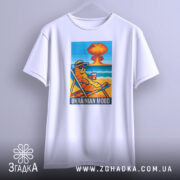 Футболка український настрій, біла, підвішена на вішалці, фон світло-сірий, принт з котом у сонцезахисних окулярах, що сидить на шезлонгу з напоєм, на фоні пляжу та вибуху.