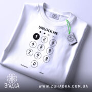 Футболка unlock me, білого кольору, складена на поверхні, фон світло-сірий, принт з клавіатурою та написом 'UNLOCK ME' чорного кольору, з зеленим ярликом.