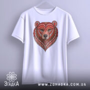 Футболка ведмідь білого кольору, підвішена на вішалці, фон світло-сірий, принт ведмедя з червоними та коричневими деталями, оформлений у стилі геометричних візерунків.