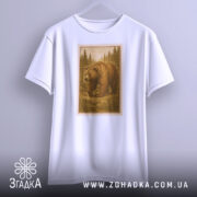 Футболка ведмідь білого кольору, підвішена на вішалці, зображена з фронтального ракурсу. Принт з ведмедем в лісі виконаний у коричневих тонах, обрамлений рамкою, що нагадує поштову марку, на фоні світло-сірого градієнту.