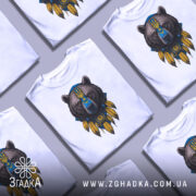 Футболка ведмідь символ, біла, зображена на манекені, фон світло-сірий, принт ведмедя з українським гербом та жовтими пір'ями.