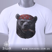 Футболка ведмідь з сигарою, біла, складена, зображення ведмедя в червоній бандані з черепами, ракурс зверху, фон світлий, на етикетці зелена стрічка.