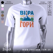 Футболка віра може рухати гори. Біла футболка з коротким рукавом, зображена на манекені з металевим блиском. На фоні світло-сірий градієнт. Принт містить текст 'ВІРА МОЖЕ РУХАТИ ГОРИ' у яскравих кольорах: синьому, оранжевому та зеленому, з малюнком гір і ліхтаря.