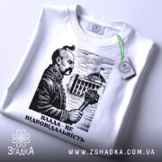 Футболка влада це відповідальність, біла футболка на столі, зображення чоловіка з вусами, що тримає скіпетр, на фоні будівлі, принт виконаний у чорному кольорі, з зеленим ярликом.