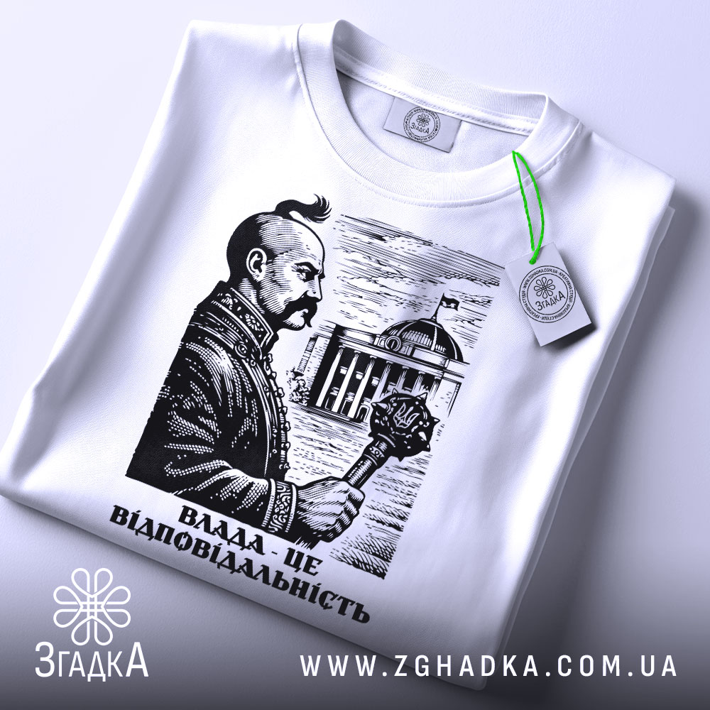 Футболка влада це відповідальність, біла футболка на столі, зображення чоловіка з вусами, що тримає скіпетр, на фоні будівлі, принт виконаний у чорному кольорі, з зеленим ярликом.