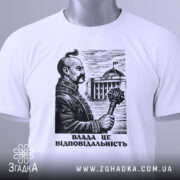 Футболка влада це відповідальність, біла футболка на столі, зображення чоловіка з вусами, що тримає скіпетр, на фоні будівлі, принт виконаний у чорному кольорі, з зеленим ярликом.