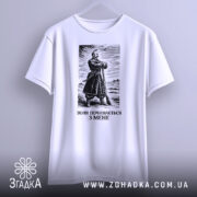 Футболка воля починається з мене. Біла футболка з коротким рукавом, зображена з фронтального ракурсу на світлому фоні. На футболці чорний принт з зображенням чоловіка в одязі 19 століття. Текст під зображенням: 'ВОЛЯ ПОЧИНАЄТЬСЯ З МЕНЕ'.