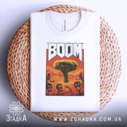 Футболка вибуховий арт BOOM білого кольору, складена на плетеній кошику, фон світло-сірий, принт з ядерним вибухом та скелетами, вид зверху.