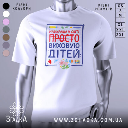 Футболка виховую дітей, біла, зображена з фронтального ракурсу, фон світло-сірий, принт містить яскраві кольори з написом 'НАЙКРАЩА У СВІТІ ПРОСТО ВИХОВУЮ ДІТЕЙ' та ілюстраціями фруктів і канцелярських предметів.