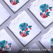 Футболка вишневі гілки, біла, зображена на манекені, фон світло-сірий, принт з червоними вишнями та зеленим листям на кольорових фонах.