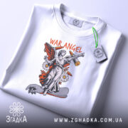 Футболка War Angel білого кольору, складена на столі, з видимим етикеткою, принт з ангелом на скейтборді, фон світло-сірий.