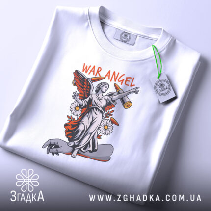 Футболка War Angel білого кольору, складена на столі, з видимим етикеткою, принт з ангелом на скейтборді, фон світло-сірий.