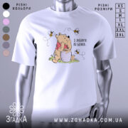 Футболка з любовʼю до бджіл, білого кольору, зображена на манекені, фон нейтральний, принт з ведмедиком, що тримає банку з медом, оточений бджолами.