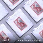 Футболка заєць лісовий, біла, зображена з фронтального ракурсу, фон світло-сірий, принт зображає червоного зайця на фоні лісу в рамці.