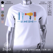 Футболка зброя перукаря, біла, зображена на манекені, фон світло-сірий, принт містить гребінець, ножиці, фен та щітку, виконаний у яскравих кольорах.